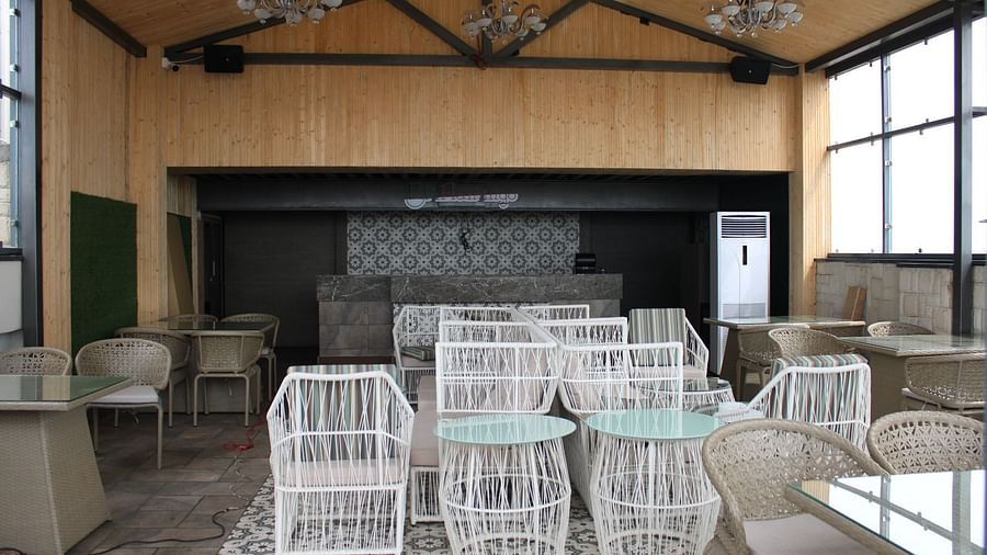 A lounge with chairs arranged neatly and ambient lights hanging from the ceiling at  BluSalzz Residence, Amritsar